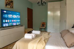 a bedroom with a bed with a flat screen tv at Claire Apartment with Garden in Sofia