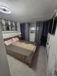 a small bedroom with a bed and a television at Cozy apartment in Nahariyya