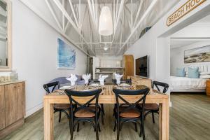 a dining room with a wooden table and chairs at Ocean Whisper At 42 in Gqeberha +47 photos