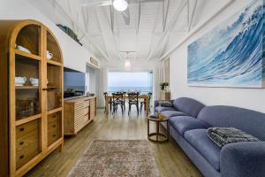 a living room with a blue couch and a table at Ocean Whisper At 42 in Gqeberha