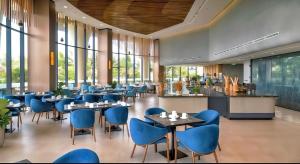 a restaurant with blue chairs and tables and windows at Alexa Villa Cam Ranh - 3 Bedrooms, Private Pool, Beach Access in Cam Lâm