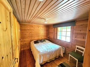 a bedroom with a bed in a wooden room at Koutakivi - Tilava mökki rinteen vieressä 2mh ja 2 parvea in Levi