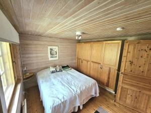 a bedroom with a bed in a room with wooden walls at Koutakivi - Tilava mökki rinteen vieressä 2mh ja 2 parvea in Levi
