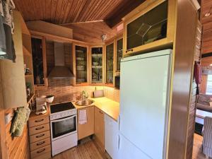 a kitchen with a refrigerator and a sink at Koutakivi - Tilava mökki rinteen vieressä 2mh ja 2 parvea in Levi