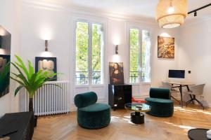 a living room with green chairs and a table at PARIS - Boulogne Résidence in Boulogne-Billancourt