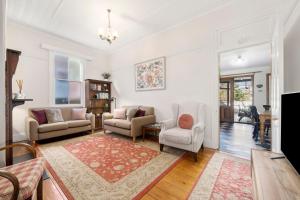 a living room with two chairs and a table at Little Pomander in Leura