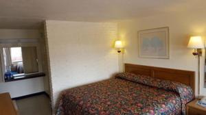 a hotel room with a bed and two lamps at Red Carpet Inn - Blacksburg in Blacksburg