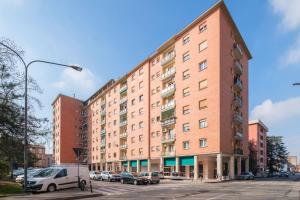 a large brick building with cars parked in a parking lot at Casita de Luna- Affittacamere Bologna in Bologna
