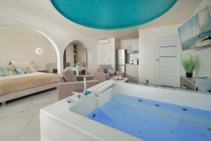 a large bath tub in a living room with a bed at Kameralny Aparthotel Elegante Władysławowo - Adults Only in Władysławowo
