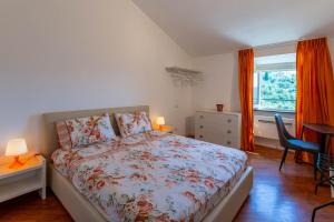 a bedroom with a bed and a desk and a window at Cava Ardè Rooms in Lavagna