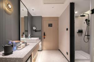 a bathroom with a sink and a shower at Atour S Hotel Ningbo Heyi Avenue in Ningbo +43 photos