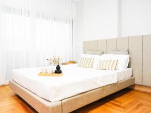a large white bed in a bedroom with white walls at Blush Studio at Rose in Prishtinë
