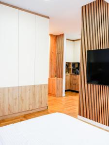 a living room with a flat screen tv on a wall at Blush Studio at Rose in Prishtinë
