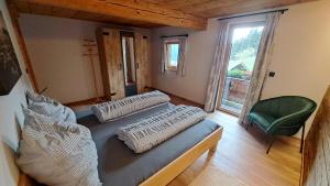 a room with a bed and a chair and a window at THENN in Jochberg