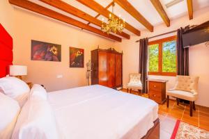 a bedroom with a large white bed and a chandelier at Es Pouet in Binissalem +32 photos