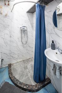ein Badezimmer mit einem blauen Duschvorhang und einem Waschbecken in der Unterkunft Apartment on Virmens`ka Street in Lwiw