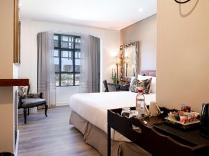 a bedroom with a bed and a desk and a mirror at ANEW Hotel Hilton Pietermaritzburg in Hilton