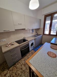 a kitchen with a sink and a stove and a table at Horizzonte Blu in Porto Alabe