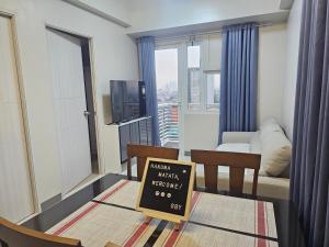 a living room with a table with a sign on it at Ermita, Manila - SM Manila in Manila