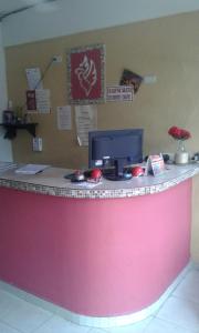 a pink counter with a computer on top of it at Rincón del Ángel in Villahermosa