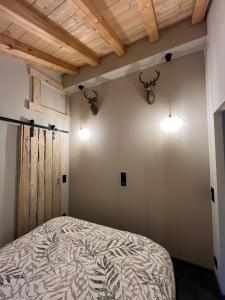 a bedroom with a bed in a room with wooden ceilings at Chalet aux pieds des stations de ski avec spa in Landry