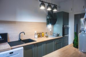 Gîte 4 étoiles, centre Monein, 4 chambres, terrasse, jusqu'à 8 pers في Monein: مطبخ مع حوض وطاولة عمل +28 صورة