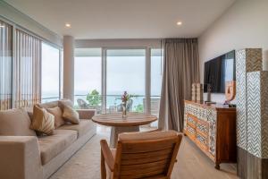 una sala de estar con un sofá y una mesa en Cozy 2-Bed Apt by the Sea Beach - KBR37, en Ban Bang Po