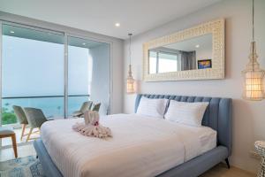 Un dormitorio con una cama con un espejo en la pared. en Cozy 2-Bed Apt by the Sea Beach - KBR37, en Ban Bang Po 16 fotos más