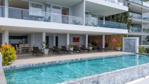 un apartamento con piscina frente a un edificio en Cozy 2-Bed Apt by the Sea Beach - KBR37, en Ban Bang Po