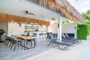 Tropical 3 Bed Pool Villa in Plai Laem - KBR42 في Plai Laem: غرفة طعام بها طاولة وكراسي