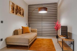 a living room with a couch in front of a sliding door at Elegant Ephesus Suites - Artemis in Selçuk
