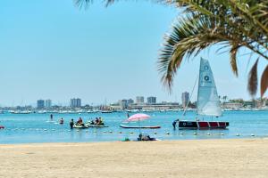 a group of people on a beach with a sail boat at Villa Estrella del Mar in San Pedro del Pinatar