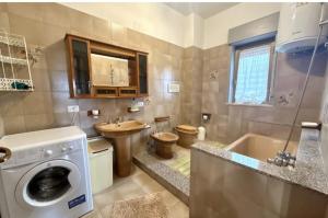 a bathroom with a sink and a washing machine at Lavinia House in Oliveri +17 photos