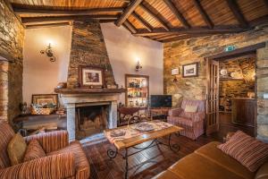 un salon rempli de meubles et d'une cheminée dans l'établissement Villa Casas de São Francisco da Chã, à Góis