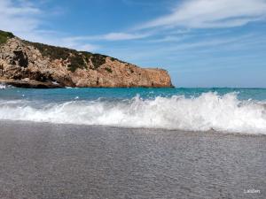 a beach with waves crashing on the shore at Camere DomusAntiga wifi in San Giovanni Suèrgiu