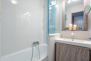 Un baño con bañera, lavabo y espejo. en Résidence à Cannes, en Cannes 36 fotos más