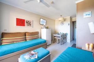 Una sala de estar con un sofá azul y una cocina. en Résidence à Cannes, en Cannes