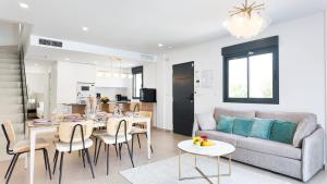 a living room with a couch and a table and chairs at Villa Estrella del Mar in San Pedro del Pinatar