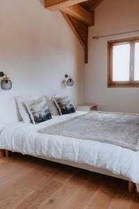 a bedroom with a large bed with white sheets at Chalet Salt Lake in La Toussuire
