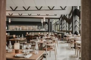 an empty restaurant with wooden tables and chairs at Hagastrand, Autograph Collection in Solna