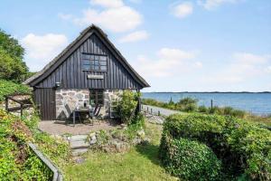 una casa-fienile con un tavolo di fronte all'acqua di FY388-Mesinge-Nordre-Skovvaenge-87 a Mesinge