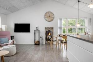 a kitchen and living room with a clock on the wall at FY396-Middelfart-Siriusvej-4 in Middelfart