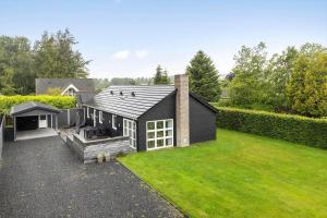 a black house with a lawn in front of it at FY396-Middelfart-Siriusvej-4 in Middelfart
