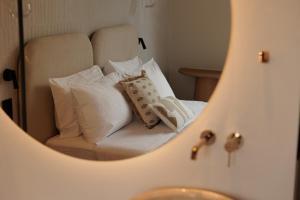 a mirror reflection of a bed with white pillows at Avia in Corfu