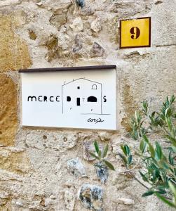 a sign on a stone wall with a picture of a house at Casa Merceditas in Corsá