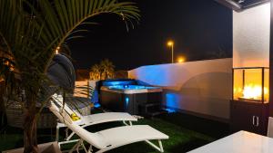 a patio with two chairs and a grill at night at Villa Estrella del Mar in San Pedro del Pinatar