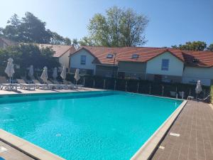 a swimming pool in front of a house at Maison 3 piscines - Résidence 3 étoiles in Pornichet