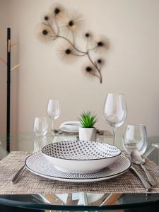 a dining room table with a plate and wine glasses at Morgado Granja Luxury Suits in Aveiro