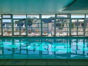 ポルニシェにあるMaison 3 piscines - Résidence 3 étoilesの青い水と窓のあるスイミングプール