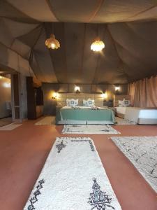 a bedroom with a bed in a tent with two rugs at ChariF Luxury Camp in Rissani